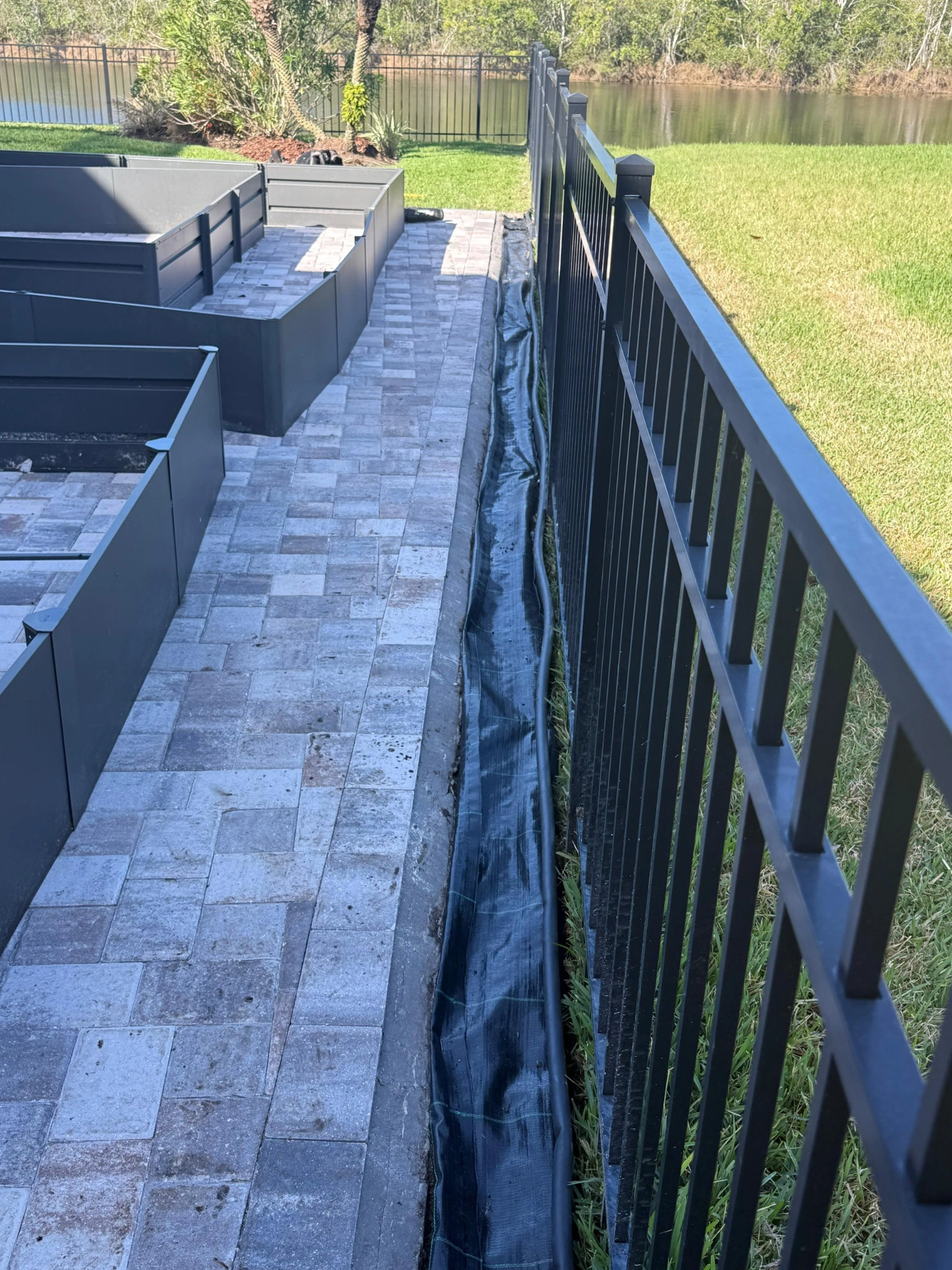 Paver patio beside a Tampa fence